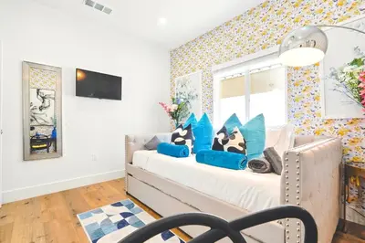 a bedroom with a bed with blue pillows at G- Luxe NoHo Family Home near Universal 15m and Hollywood 10m in Hewitt