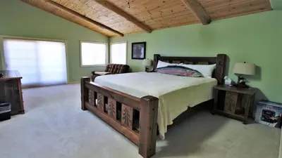 a bedroom with a large wooden bed and green walls at Lakeside Oasis in Big Bear Lake