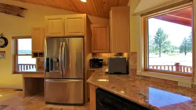 a kitchen with a stainless steel refrigerator and a window at Lakeside Oasis in Big Bear Lake