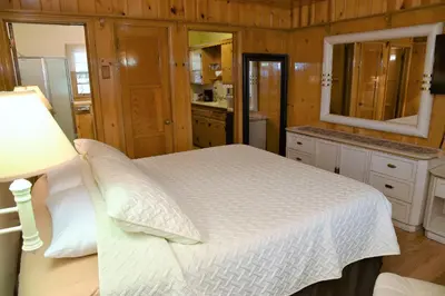 a bedroom with a bed and a sink and a mirror at The Kern Lodge in Kernville