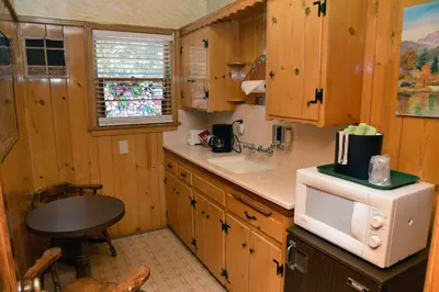 a kitchen with wooden cabinets and a white microwave at The Kern Lodge in Kernville