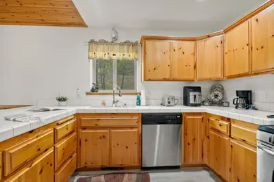a kitchen with wooden cabinets and a dishwasher at Sea to Ski Retreat in Big Bear Lake