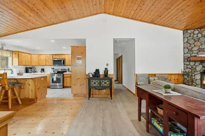 an open kitchen and living room with wooden cabinets at Sea to Ski Retreat in Big Bear Lake