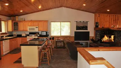 a kitchen with a fireplace and a living room at Hot Tub/Game Tables/Dogs OK - Aspen Glen in Big Bear Lake