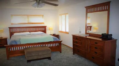 a bedroom with a bed and a dresser and a mirror at Hot Tub/Game Tables/Dogs OK - Aspen Glen in Big Bear Lake