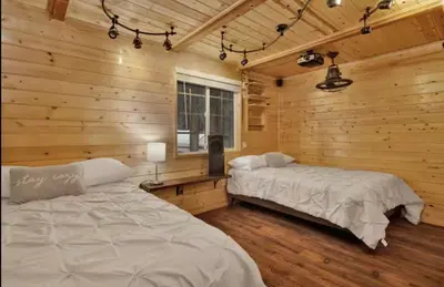 a bedroom with two beds in a log cabin at Moab Cozy Lane HotTub & Game Room with Pool Table in Big Bear Lake