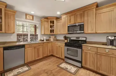 a kitchen with wooden cabinets and black appliances at Moab Cozy Lane HotTub & Game Room with Pool Table in Big Bear Lake