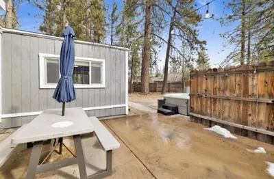 a blue umbrella sitting on a table next to a fence at Moab Cozy Lane HotTub & Game Room with Pool Table in Big Bear Lake