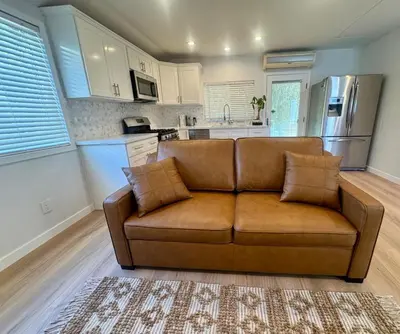 a living room with a brown couch in a kitchen at PRIVATE modern studio Guesthouse in Los Angeles