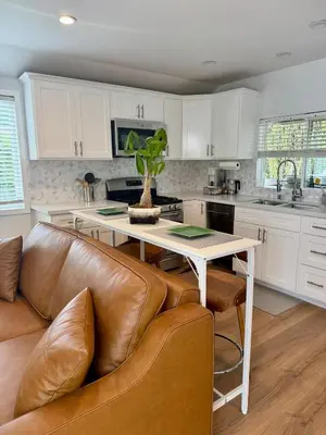 a kitchen with a table and a leather couch at PRIVATE modern studio Guesthouse in Los Angeles
