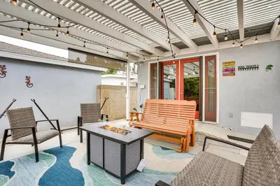 a patio with a bench and chairs and a table at 2 Mi to Cal State Long Beach Bungalow with Hot Tub! in Long Beach