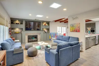 a living room with blue couches and a fireplace at 2 Mi to Cal State Long Beach Bungalow with Hot Tub! in Long Beach