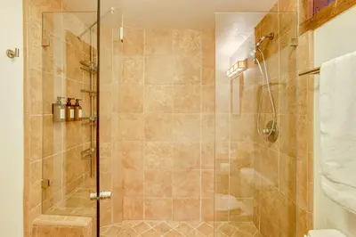a shower with a glass door in a bathroom at Walk to Lake Gregory Family Retreat with Patio! in Crestline