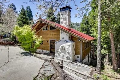 a cabin in the woods with a red roof at Walk to Lake Gregory Family Retreat with Patio! in Crestline