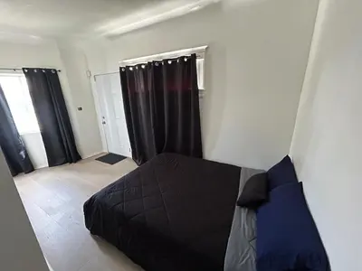 a bedroom with a black bed and black curtains at Hollywood Home in Los Angeles