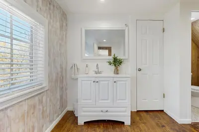 a white bathroom with a sink and a mirror at Elevation Escape in Lake Arrowhead