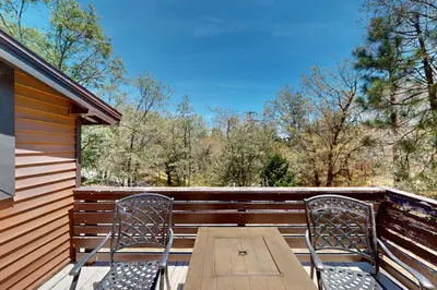 a wooden table and two chairs on a porch at Elevation Escape in Lake Arrowhead