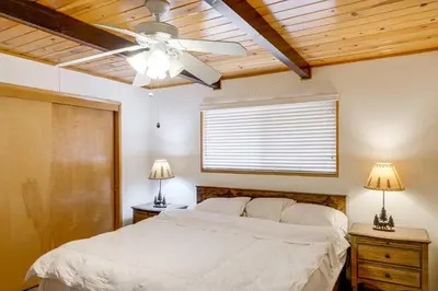 a bedroom with a white bed and a ceiling fan at Mountain-View Haven with Deck in Pine Mountain Club in Frazier Park
