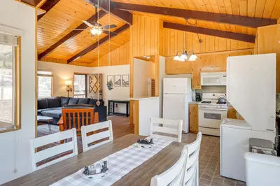 a kitchen and living room with wooden ceilings at Mountain-View Haven with Deck in Pine Mountain Club in Frazier Park