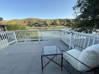 a chair and a table on a balcony with a lake at Serene Lakefront Escape in LA in Lake Hughes
