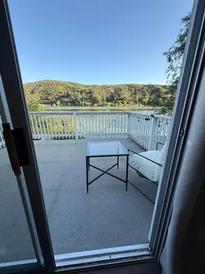 a table on a balcony with a view of the water at Serene Lakefront Escape in LA in Lake Hughes