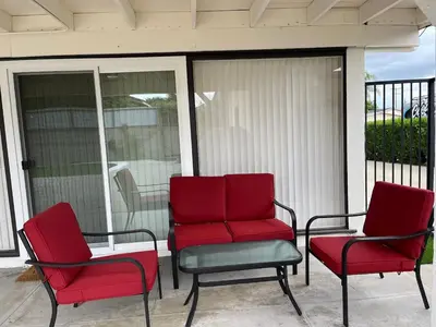 three red chairs sitting on a screened in porch at New Renovated 3B2B house in West Covina