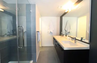 a bathroom with a shower and a sink and a mirror at Prime Stays - Suite Elegance by MDR Marina & Venice - Pool, Hot Tub, Gym in Los Angeles