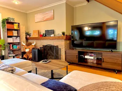a living room with a large flat screen tv at West LA - Family House & Private Yard - 10 mins from LAX & Beach in Los Angeles