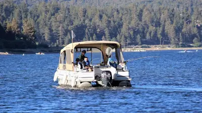 a man and a child in a small boat in the water at Bluebird Cottage in Big Bear Lake