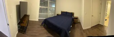 a bedroom with a bed with blue sheets and a window at Poolside Palace in Los Angeles
