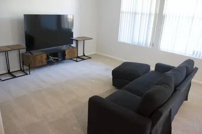 a living room with a couch and a flat screen tv at Luxury 3 Bedroom Apartment in Santa Clarita