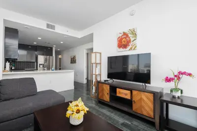 a living room with a couch and a tv at 3-Bed High-Rise with Panoramic Views, Pool & Spa in Los Angeles