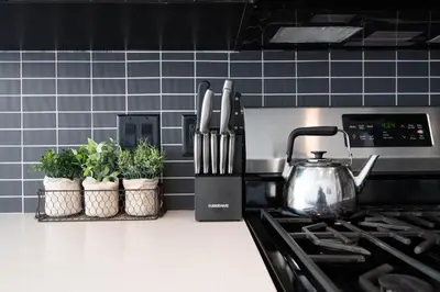a kitchen counter with a tea kettle and potted plants at 3-Bed High-Rise with Panoramic Views, Pool & Spa in Los Angeles