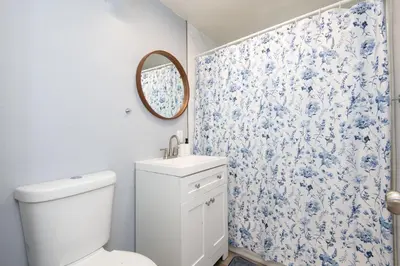 a bathroom with a toilet and a blue and white floral shower curtain at 3bedroom 2bath Unit complementary parking onsite in Los Angeles