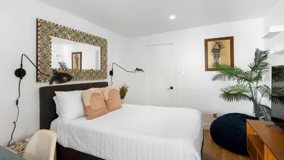 a bedroom with a bed with a mirror on the wall at Chic LA Hideaway w Soaking Tub Firepit Lounge Tranquil Backyard in Los Angeles