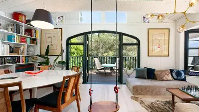 a living room with a table and a couch at Chic LA Hideaway w Soaking Tub Firepit Lounge Tranquil Backyard in Los Angeles