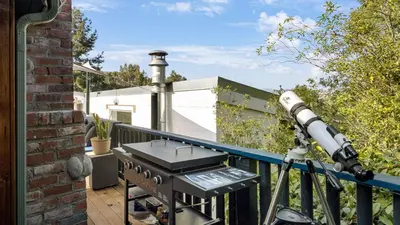 a camera on a balcony with a telescope at Chic LA Hideaway w Soaking Tub Firepit Lounge Tranquil Backyard in Los Angeles