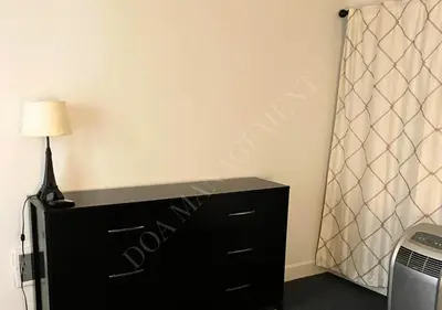 a black dresser with a lamp on top of it at Luxury condo in the heart of LA in Los Angeles