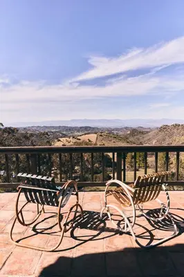 two benches sitting on a balcony looking out at the mountains at Malibu ranch retreat in Malibu