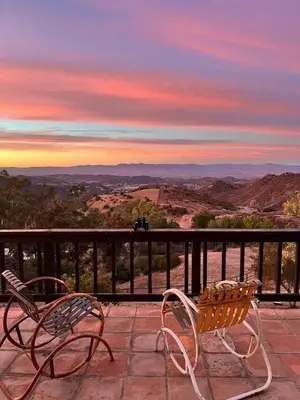 two chairs on a balcony with a view of the mountains at Malibu ranch retreat in Malibu