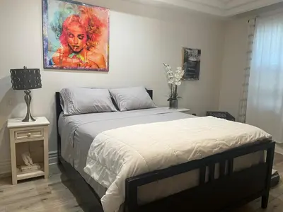 a bedroom with a bed with a painting on the wall at Studio City Chic Large Contemporary Condo in Los Angeles