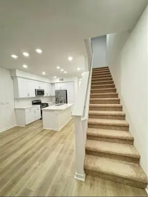a staircase in a white kitchen with a stair case at HelloLA in Whittier