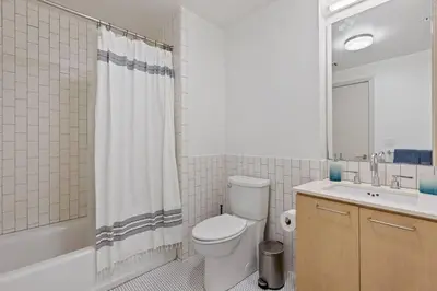 a bathroom with a toilet and a sink and a shower curtain at Emerald Ridge - Luxe Hollywood Walk of Fame in Los Angeles