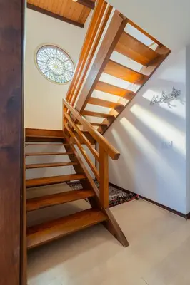a wooden staircase in a house with a stained glass window at Malibu Villa with Beach Access and Ocean View in Malibu