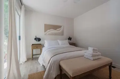 a white bedroom with a large bed and a window at Malibu Villa with Beach Access and Ocean View in Malibu