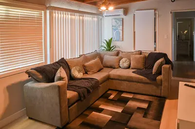 a living room with a large brown couch at Relaxing Cozy Back House with Backyard in Upland