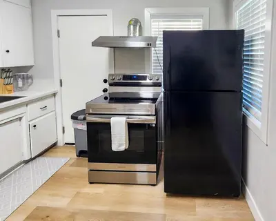 a kitchen with a black refrigerator and a stove at Relaxing Cozy Back House with Backyard in Upland