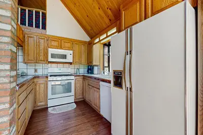 a kitchen with wooden cabinets and a white refrigerator at Villa Elvira in Lake Arrowhead
