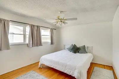 a white bedroom with a bed and a ceiling fan at 12 Mi to Dtwn LA Family Home with Patio and Yard! in Downey