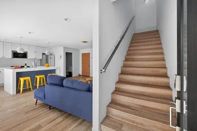 a staircase in a house with a blue couch and a kitchen at Your Coastal Getaway in Manhattan Beach Awaits in Manhattan Beach